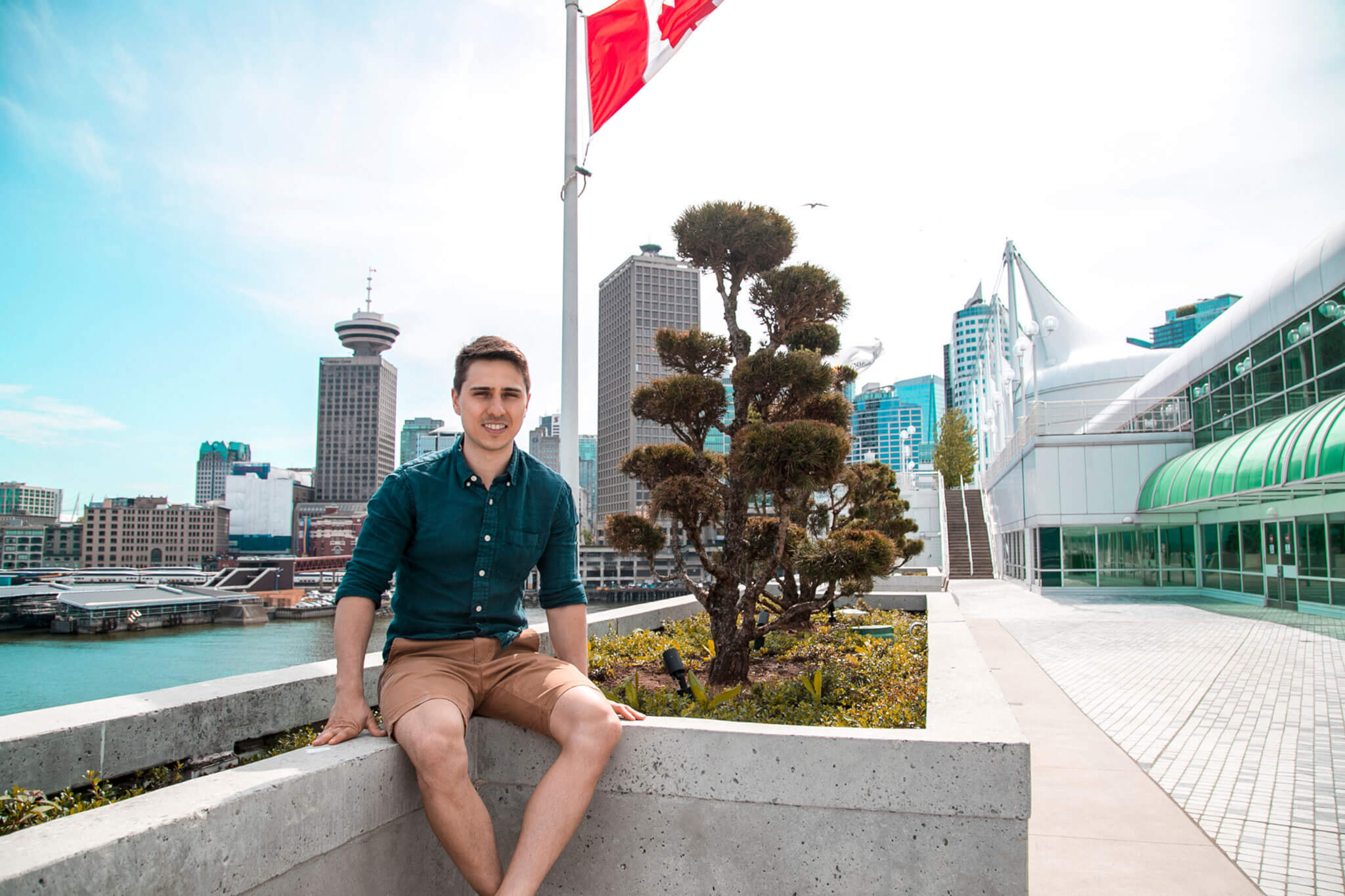 An international student sitting on a bench overlooking the Vancouver Lookout Tower
