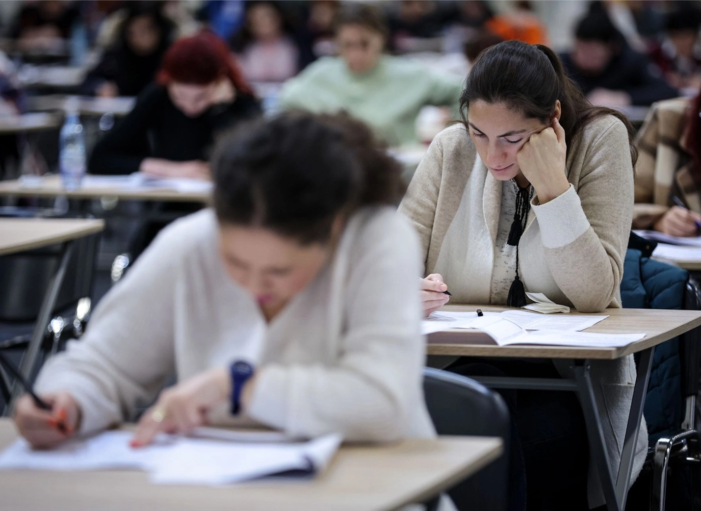 Students sit in an examination hall for a written test.