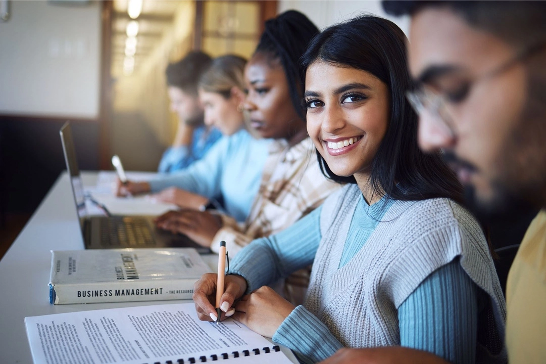 A smiling student in a classroom setting.