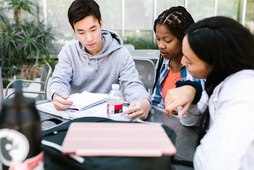 Three students study together.