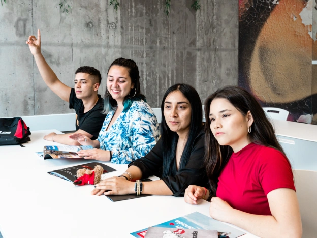Four multicultural students sharing a desk at ILAC