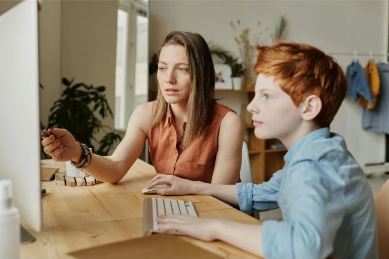 Mother teaching her child on the computer.