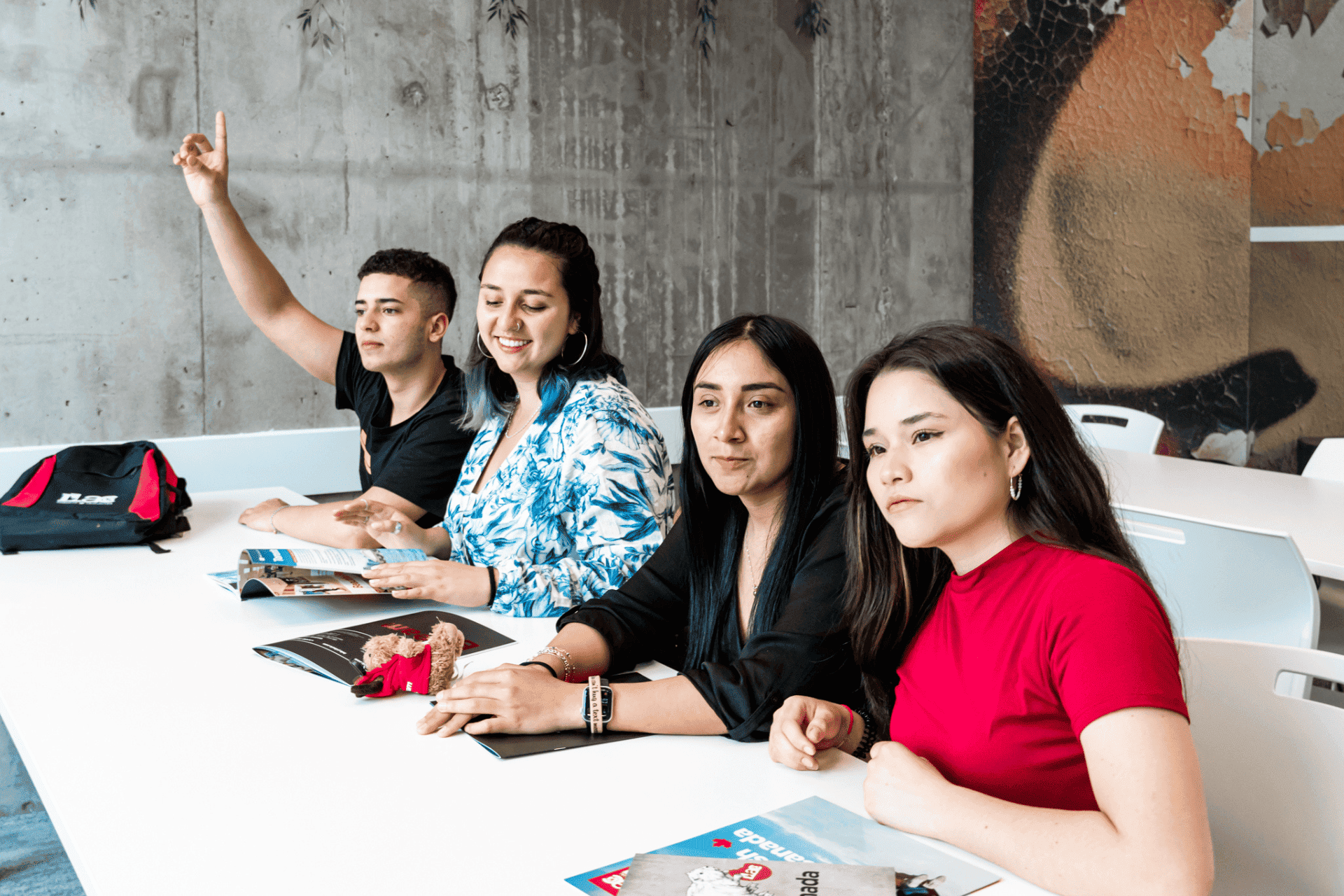 Four multicultural students sharing a desk at ILAC