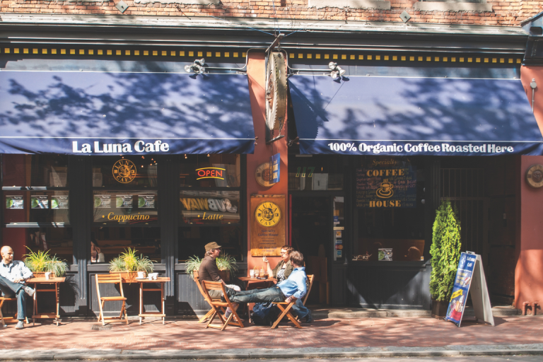 Three adults having a conversation outside a cafe