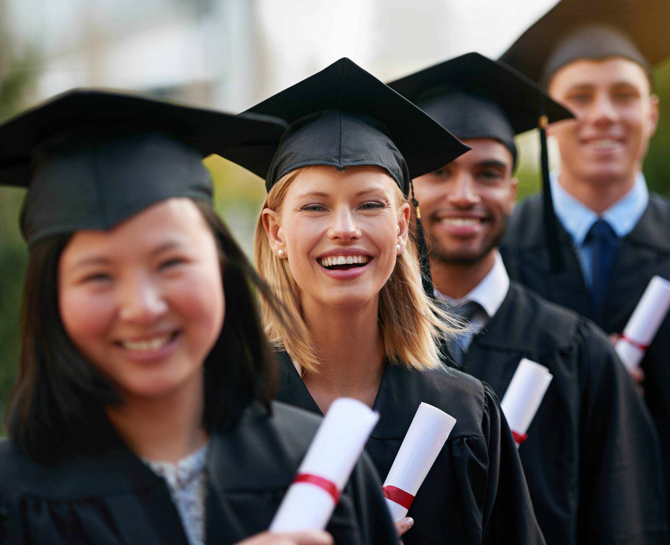 Graduating students holding diplomas
