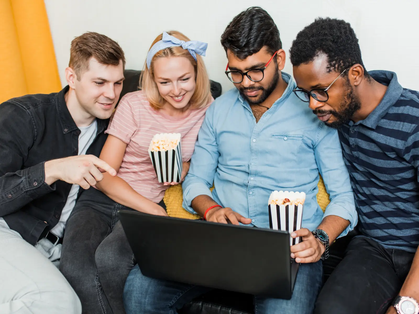 Students watching a show on a laptop while eating popcorn